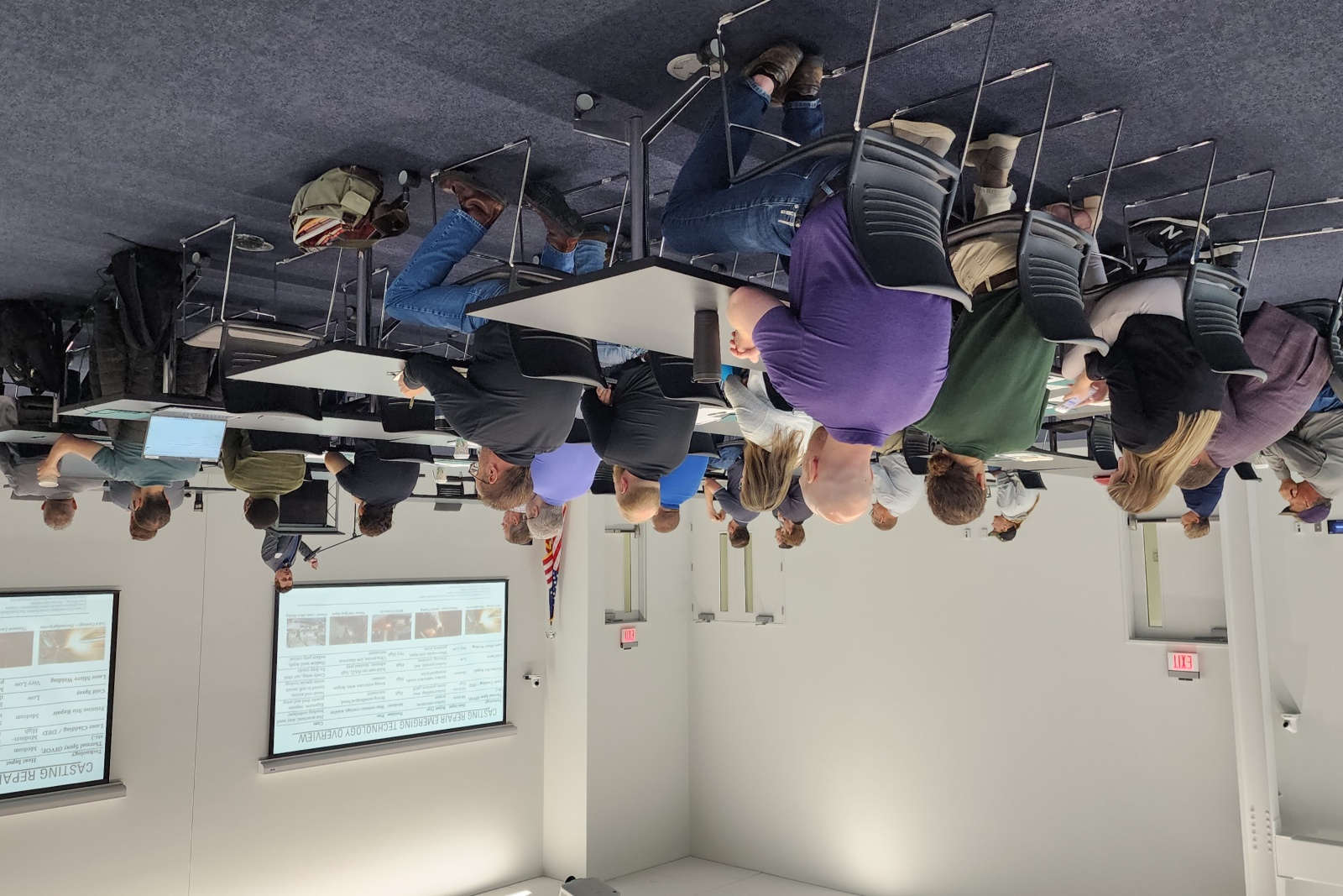 A group of people sit at tables during a workforce training